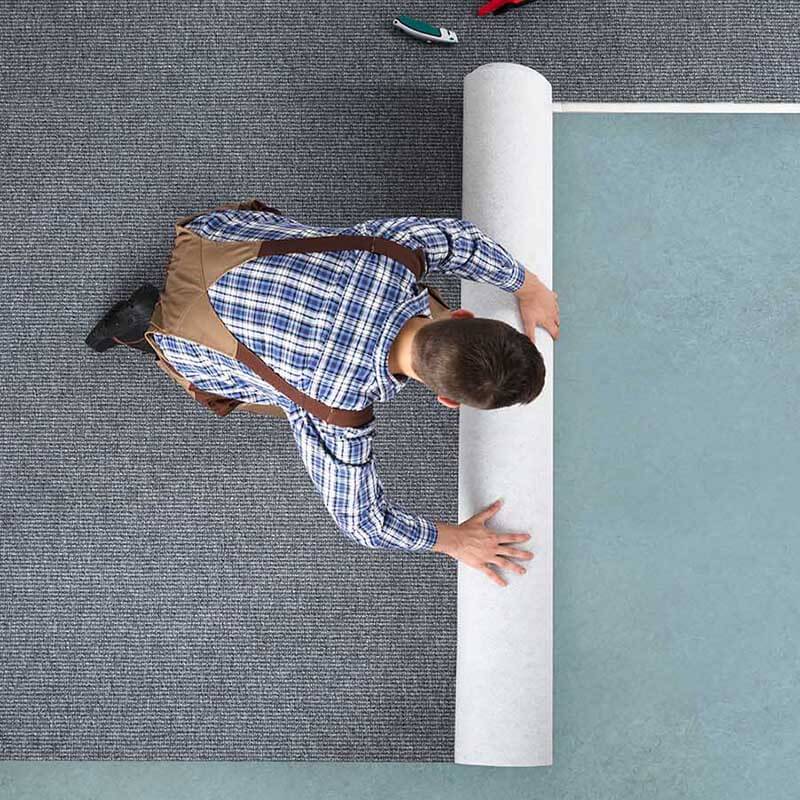 Worker installing carpet on floor | The L&L Company